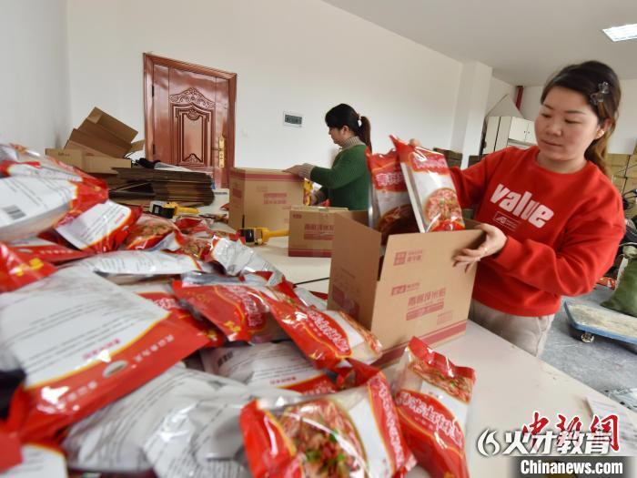 11月3日，在双峰县经开区电子商务产业园，一家电商企业员工将米粉打包装箱。乃继辉 摄
