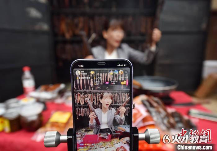 11月3日，双峰县走马街镇增新村，一家电商企业主播在网络直播销售现场熏制的腊肉。乃继辉 摄